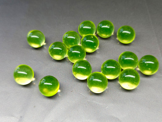Uranium glass beads glowing green under UV ultraviolet light